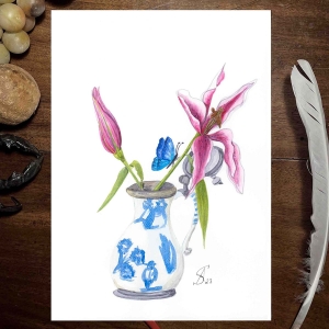 Blumenbild. Zwei rosafarbene Lilienblüten, eine geschlossen, eine geöffnet in einem Fayencekrug, der mit Chinoiserie in blau bemalt ist. Ein blauer Schmetterling sitzt auf dem Stängel einer Blume.