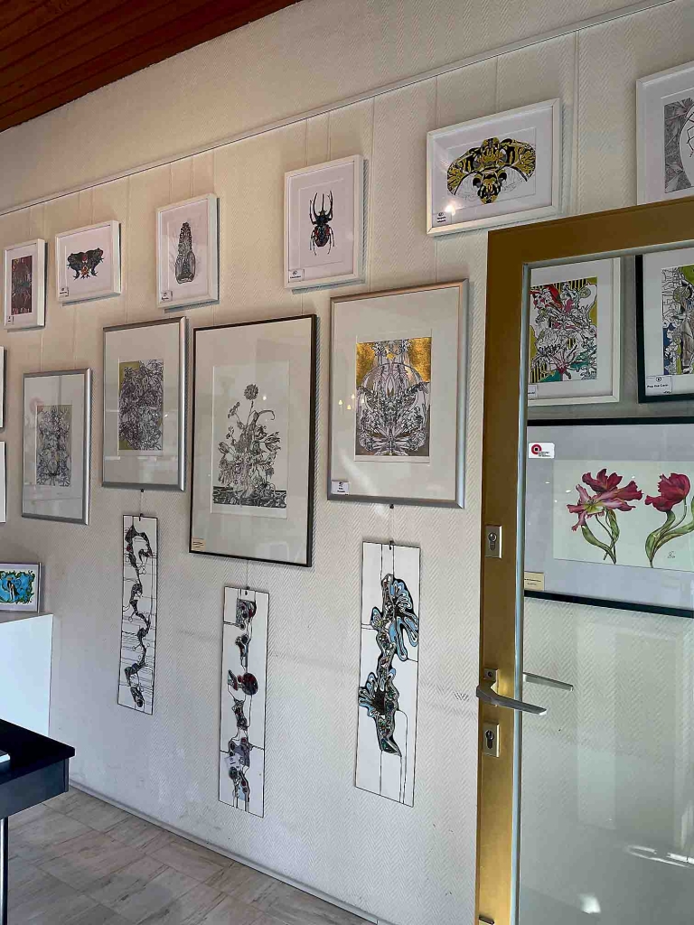Ausstellungsraum. Eine Wand mit Bilder von Blumen, Pflanzen und Insekten.